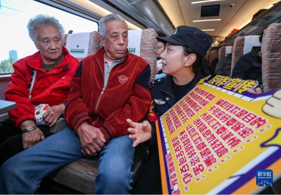 2023年10月16日,沈阳铁路公安局沈阳公安处乘警支队女子乘务大队民警在列车上向老年乘客进行反诈骗宣传。新华社记者 龙雷 摄